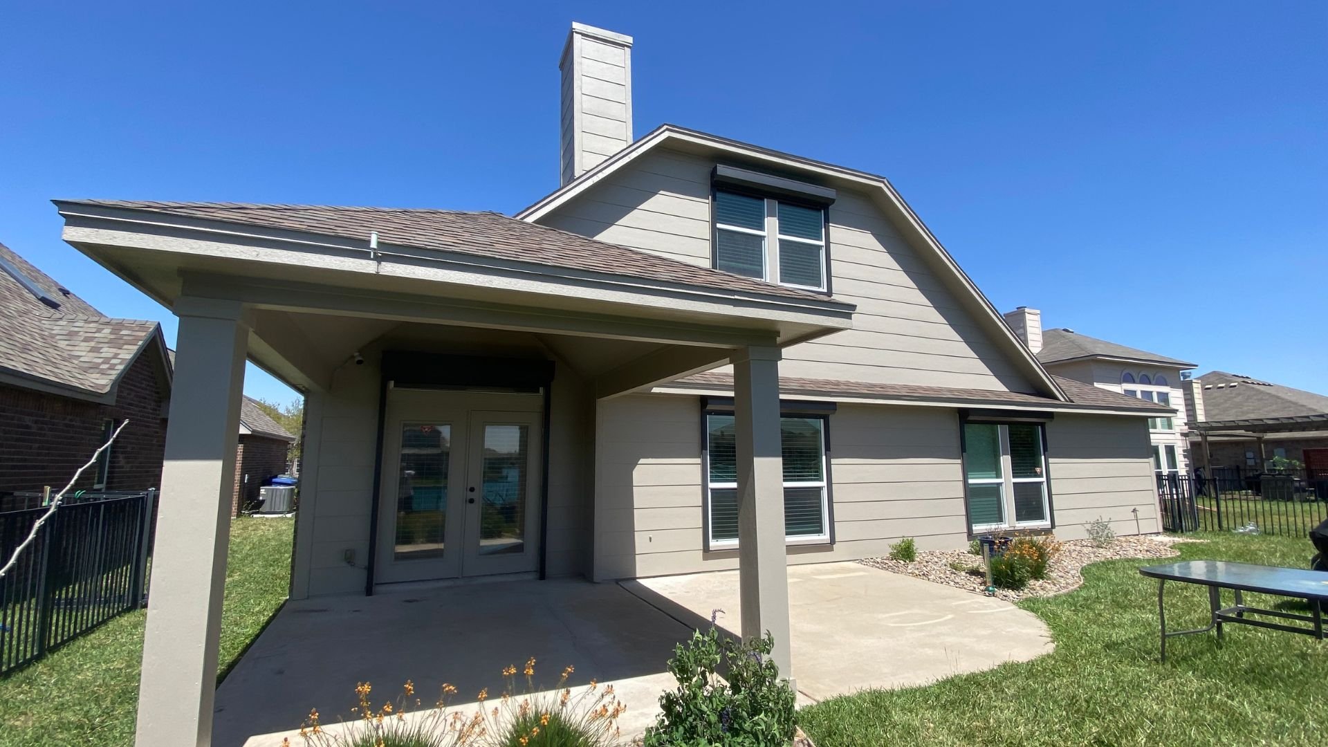 Modern two-story house with covered porch on sunny day