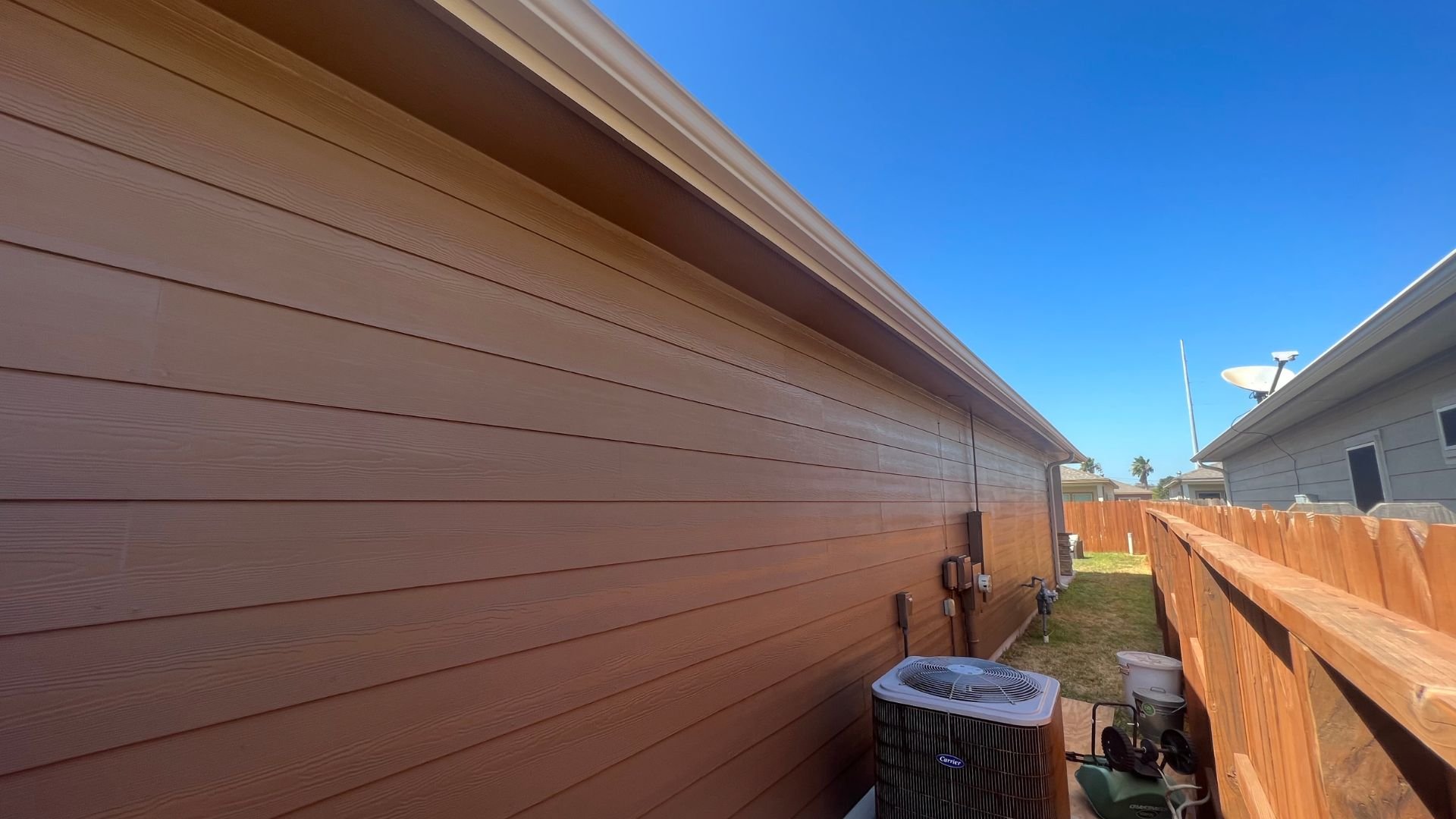 Wooden house exterior with air conditioning unit and wooden fence