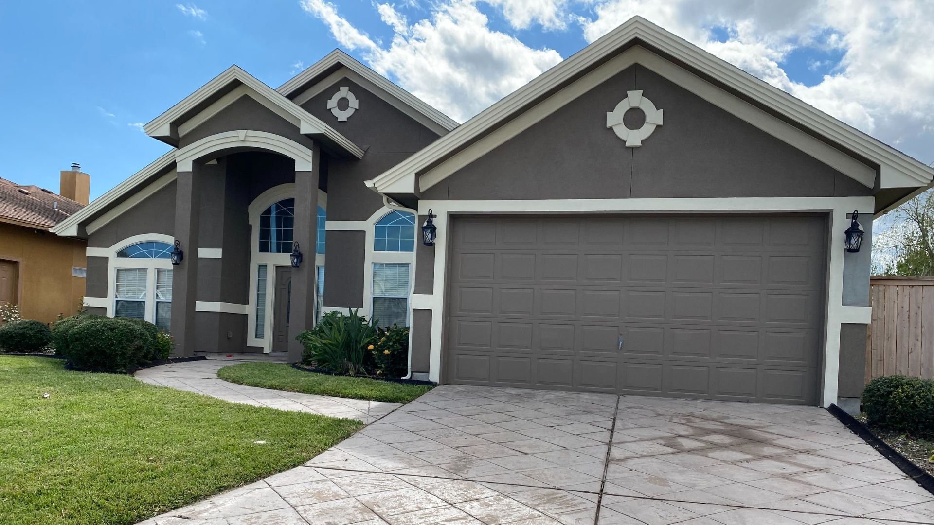 Modern two-story gray house with two-car garage and manicured lawn
