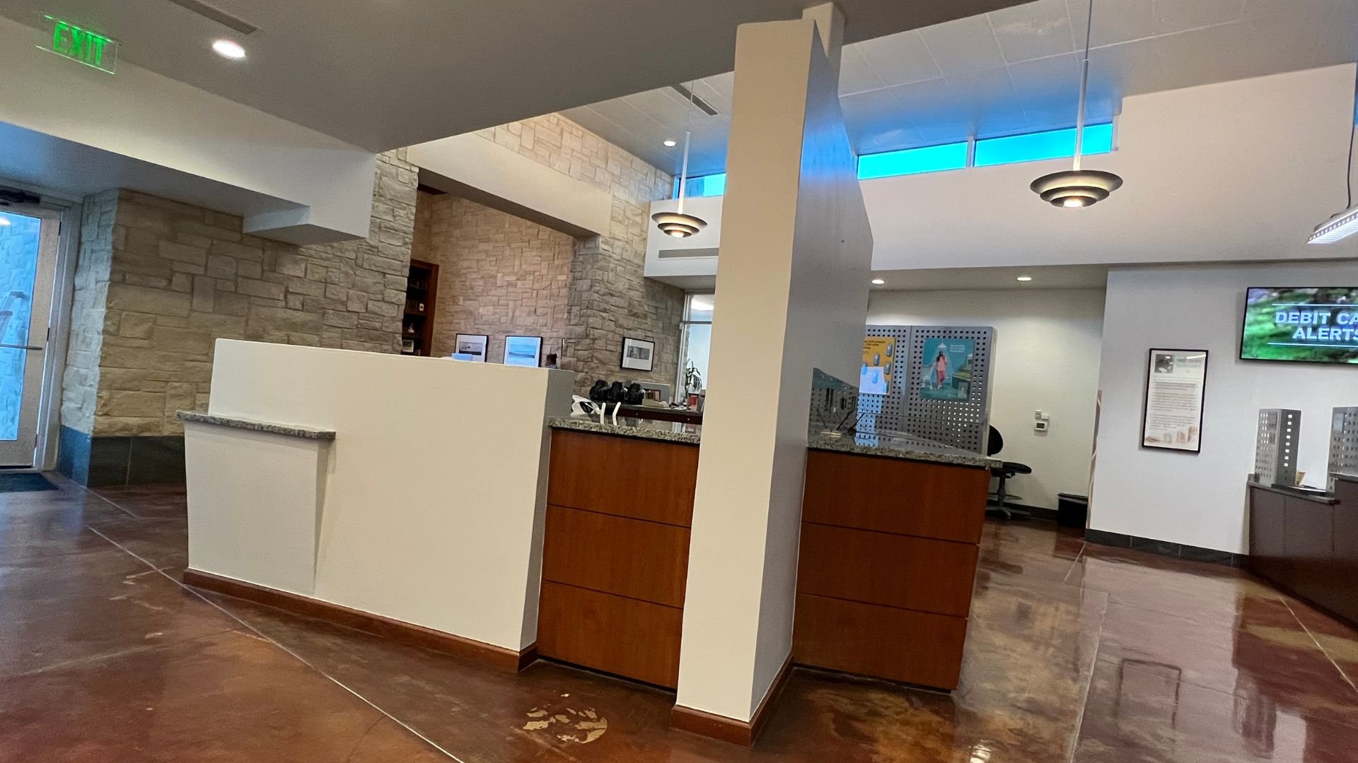 Modern office reception area with stone wall and wooden front desk