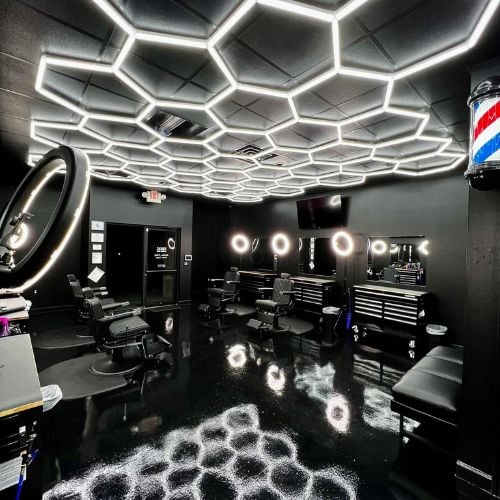 Modern barbershop with hexagonal lighting and reflective black interior
