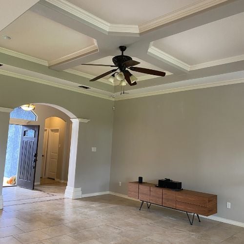 Empty room with arched doorway, ceiling fan, and wooden media console